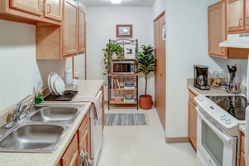 A kitchen with a white oven and a white sink.