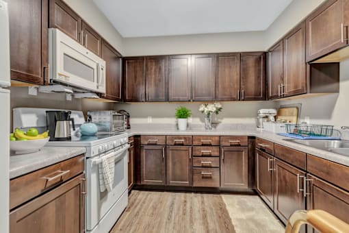 A kitchen with wooden cabinets and a white stove top oven.