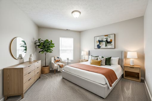 A bedroom with a large bed, a dresser, and a mirror.