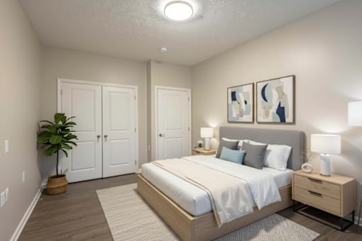 A bedroom with a bed, nightstand, and two framed pictures on the wall.