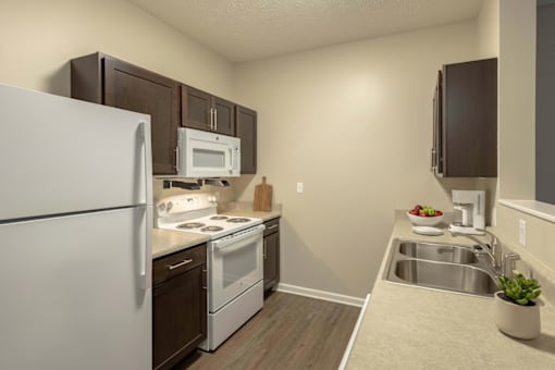 A kitchen with a white refrigerator, stove, and oven.