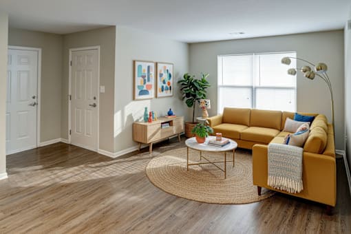 A living room with a yellow couch and a coffee table.