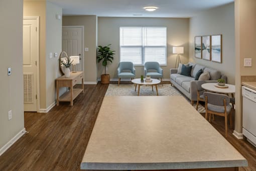 A living room with a couch, chairs, and a table.