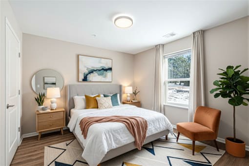 A bedroom with a large bed and a chair.
