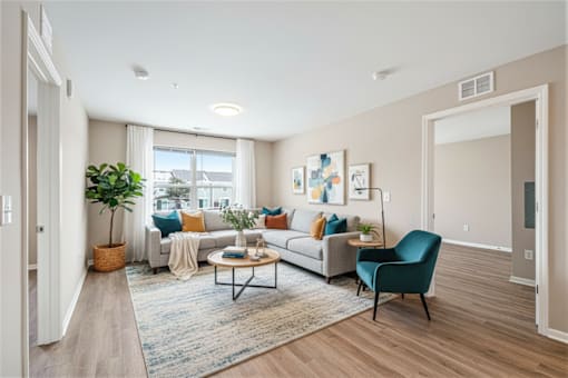A living room with a white couch, a green chair, and a coffee table.
