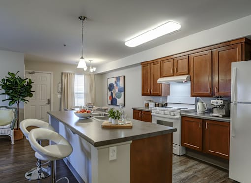 A modern kitchen with white appliances and wooden cabinets.