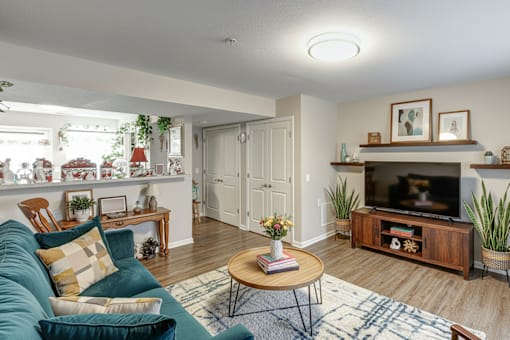 A living room with a green couch and a wooden coffee table.