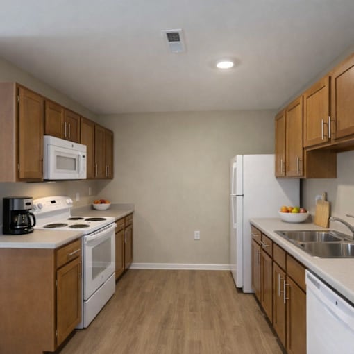 A kitchen with white appliances and wooden cabinets.