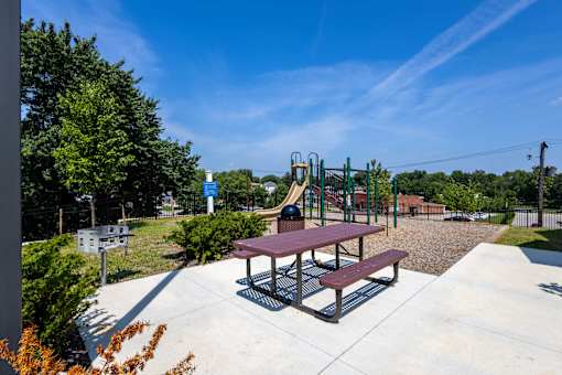 A playground with a slide and picnic table.