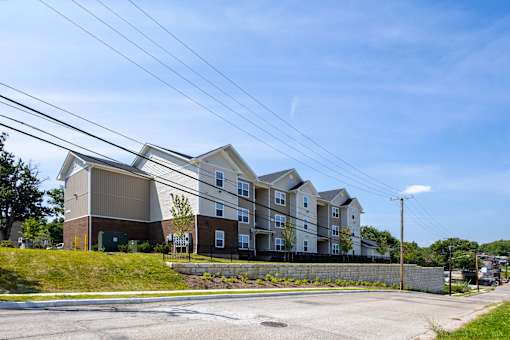 A large apartment building with a parking lot in front.