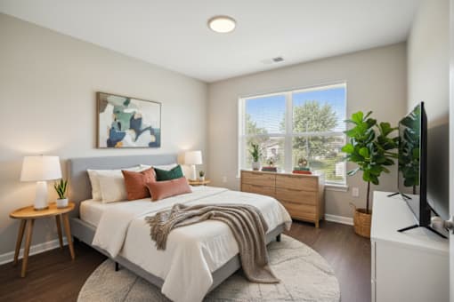 A bedroom with a large bed and a painting on the wall.
