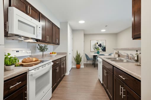 A kitchen with brown cabinets and a white stove top oven.