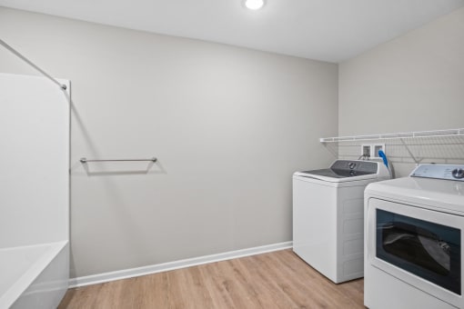 an empty laundry room with two washes and a dryer in it