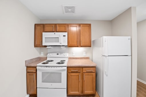 a kitchen with white appliances and wooden cabinets