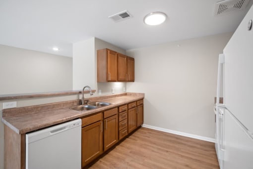 a kitchen with wooden cabinets and a sink and a refrigerator
