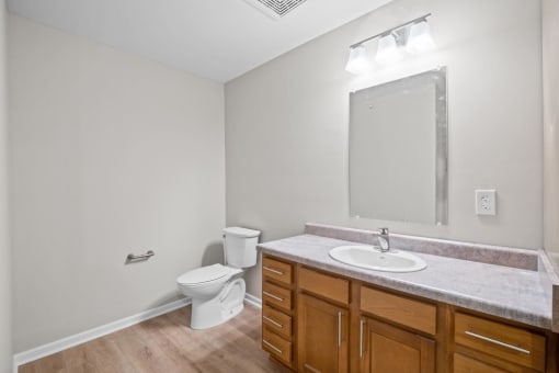 a bathroom with a sink toilet and a mirror