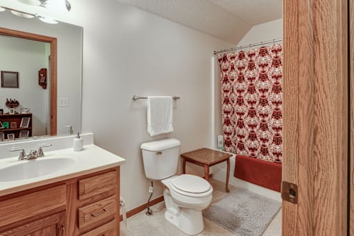 A bathroom with a toilet, sink, and shower curtain.