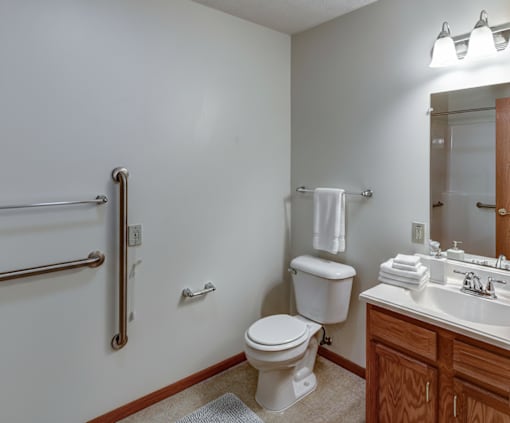 A white toilet sits in a bathroom next to a white sink.