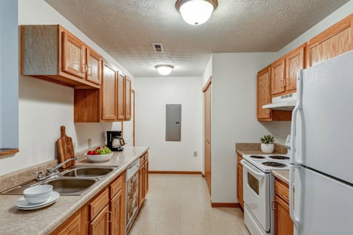A kitchen with wooden cabinets and a white refrigerator.