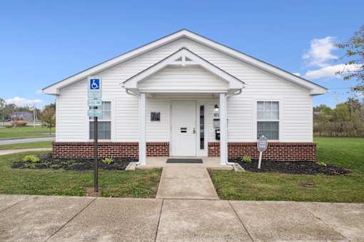A white church with a blue handicap sign in front.