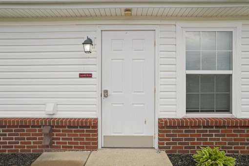 A white door with a red sign above it.