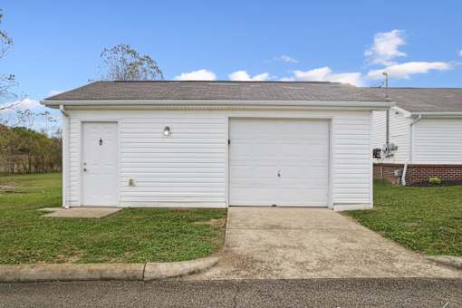 A two-car garage with a white door and a brown roof.