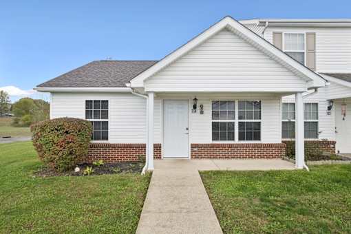 A white house with a grey roof and a white door.