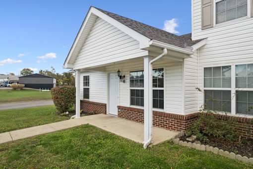 A white house with a covered front porch.