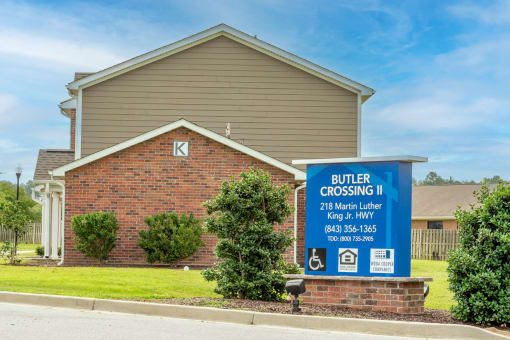 a sign in front of a brick house that says butter crossing ii