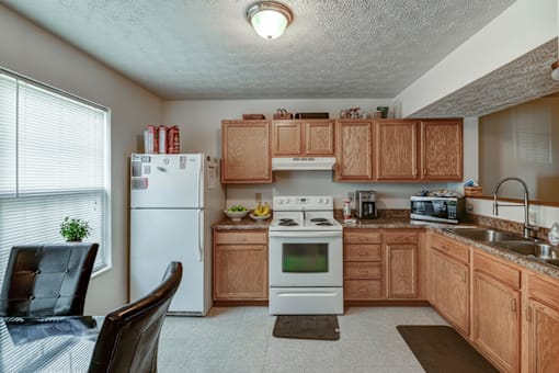 A kitchen with wooden cabinets and a white refrigerator.