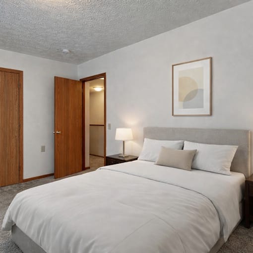 A bedroom with a large bed and a painting on the wall.
