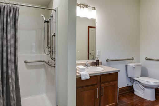 A bathroom with a toilet, sink, and shower.