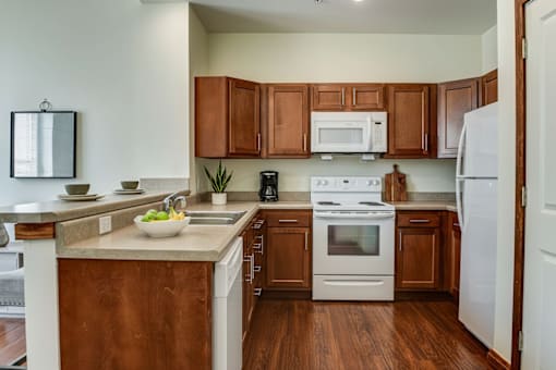 A kitchen with wooden cabinets and white appliances.