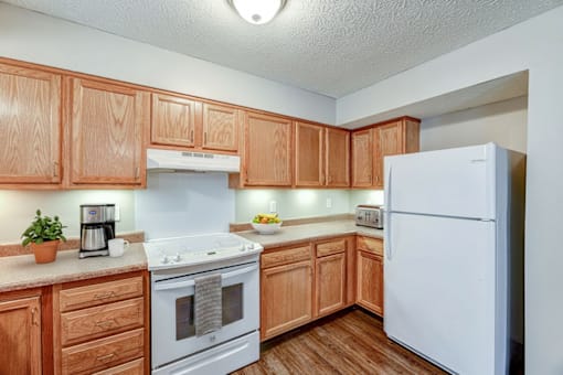A kitchen with wooden cabinets and a white refrigerator.