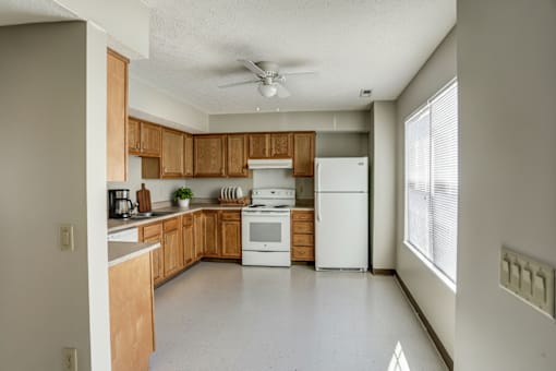 A kitchen with wooden cabinets and white appliances.