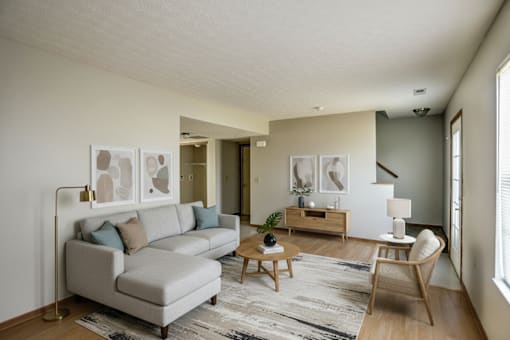 A living room with a grey couch, a wooden coffee table, and a rug.