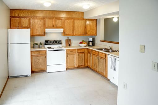 A kitchen with wooden cabinets and white appliances.