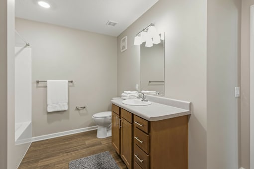 A bathroom with a white sink and a white towel hanging on the wall.