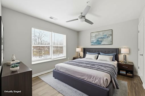 A bedroom with a large bed and a ceiling fan.