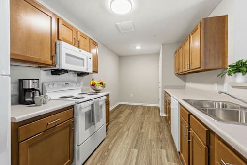 A kitchen with wooden cabinets and white appliances.