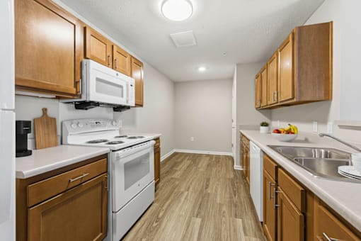 A kitchen with wooden cabinets and white appliances.