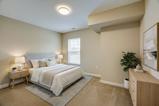 A bedroom with a bed, nightstand, and a plant.
