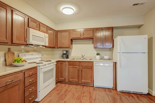 A kitchen with wooden cabinets and white appliances.