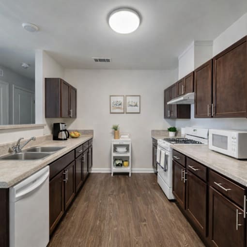 A kitchen with brown cabinets and white appliances.