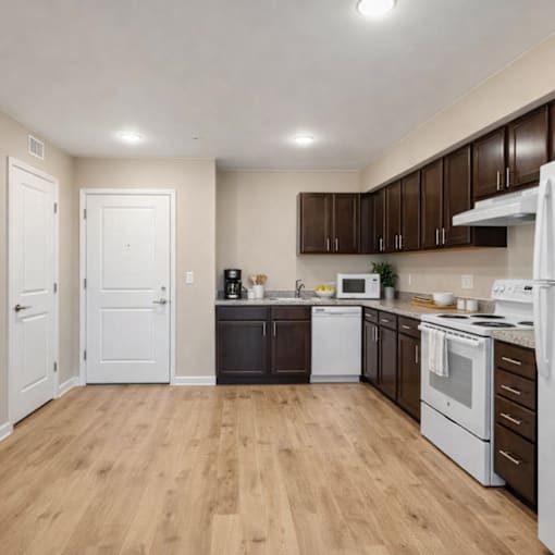 A kitchen with white appliances and brown cabinets.