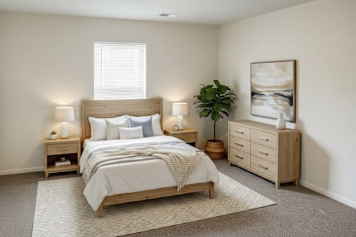 A bedroom with a large bed, nightstands, and a plant.