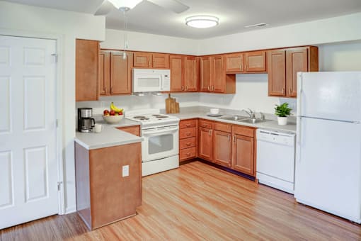 A kitchen with wooden cabinets and white appliances.