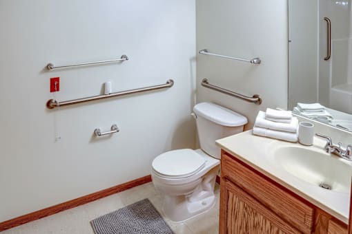 A white toilet sits next to a sink in a bathroom.