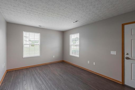 A room with a wooden floor and a white door.