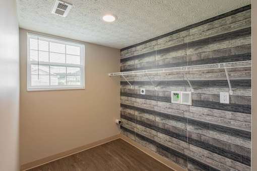 A room with a wooden wall and a window.